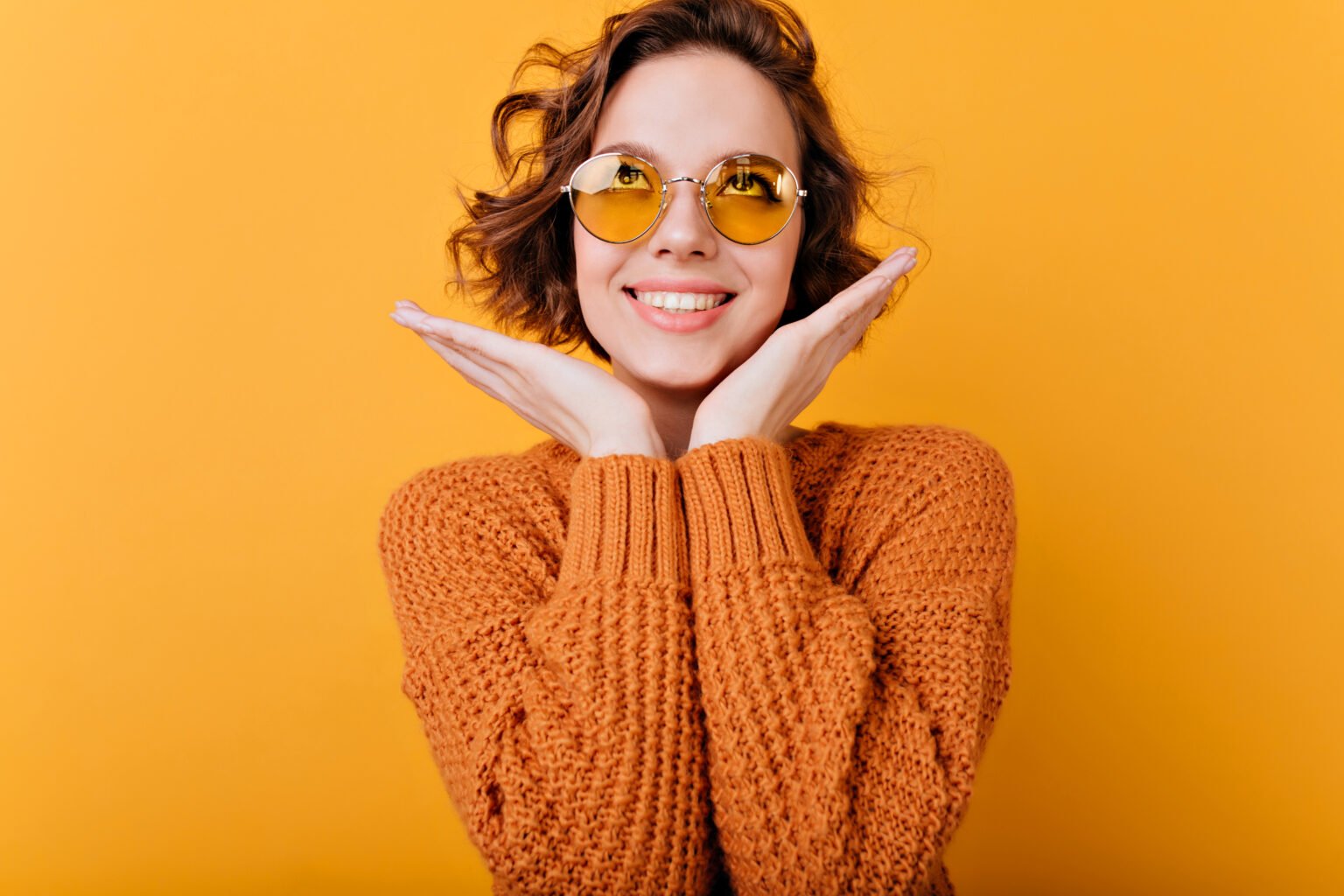 Close-up portrait of winsome laughing girl in vintage accessories. Indoor photo of cute smiling woman with wavy hairstyle having fun..