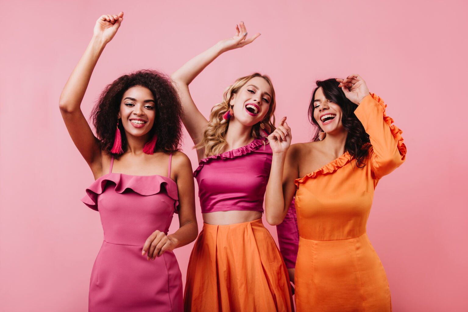 Excited girls in bright outfit expressing happiness. Latin woman spending time with friends.